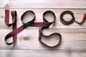 La palabra yoga escrita con correas de yoga y un mala