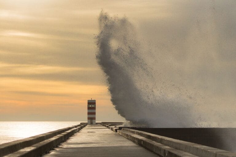 Un ejemplo del instante decisivo: una ola rompe y se eleva sobre un muelle